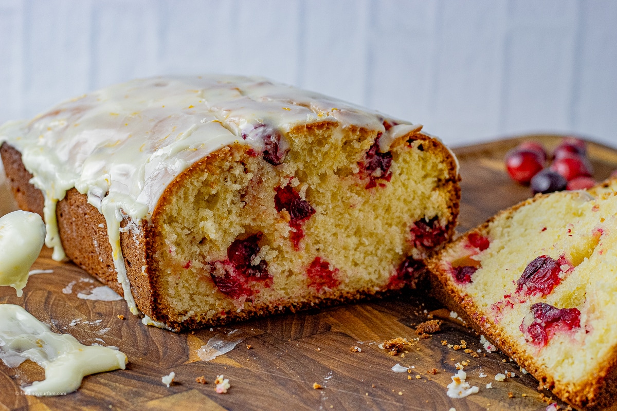 sliced cranberry orange bread on a wooden cutting board