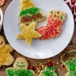 cut out cookies in a star, tree, stocking shapes with sprinkles