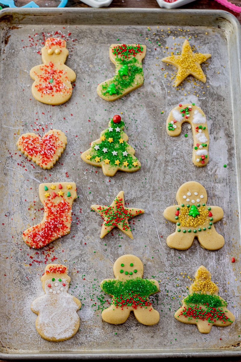 cut out cookies decorated with sprinkles on a cookie sheet
