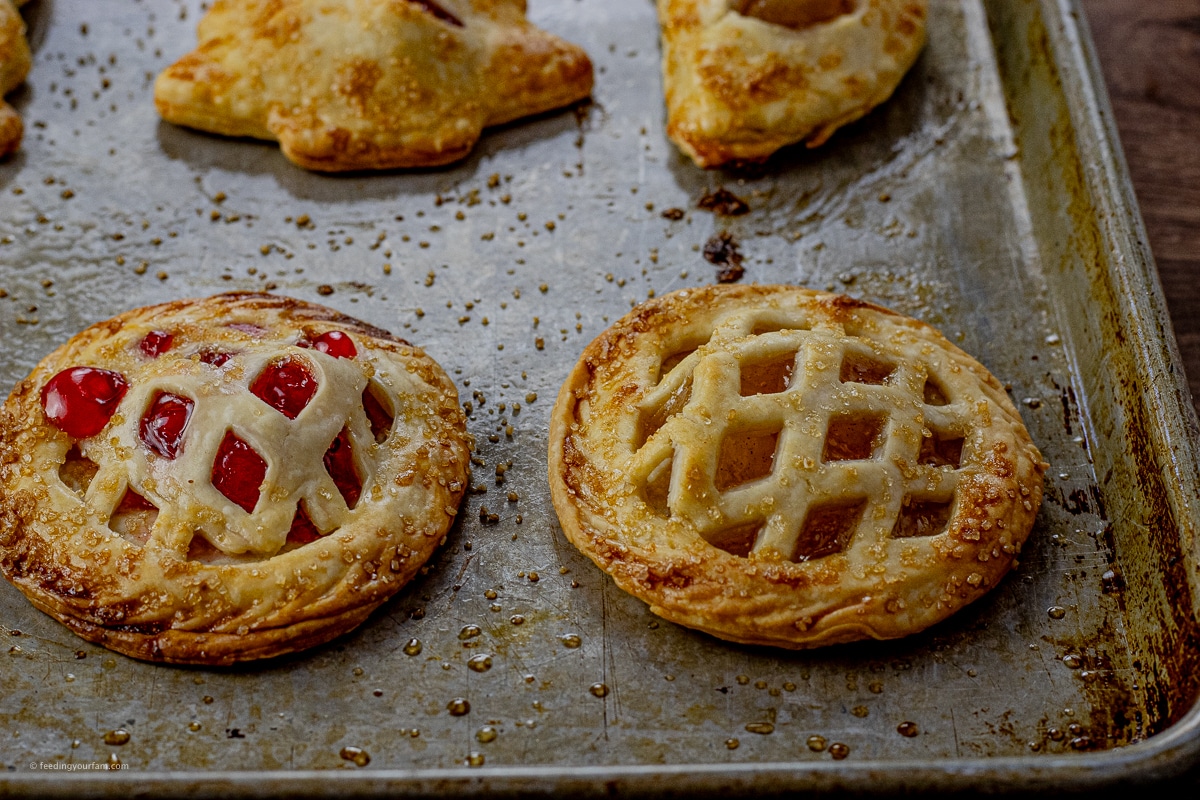 small baked hand pies filled with fruit and cooked on a baking sheet