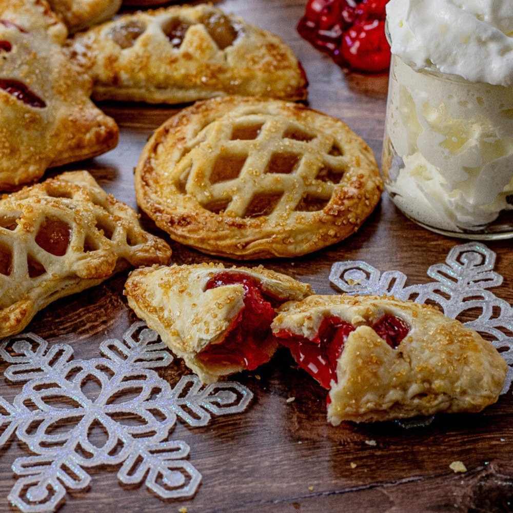 small pies in different shapes filled with fruit. One pie is broken in half with the fruit falling out