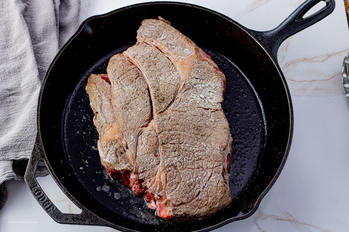 browned chuck roast in a cast iron pan