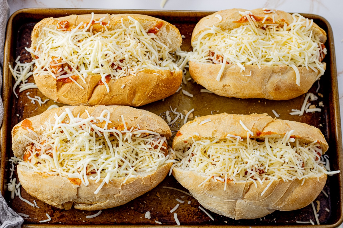 hoagie buns split and filled with meatballs and topped with shredded mozzarella cheese
