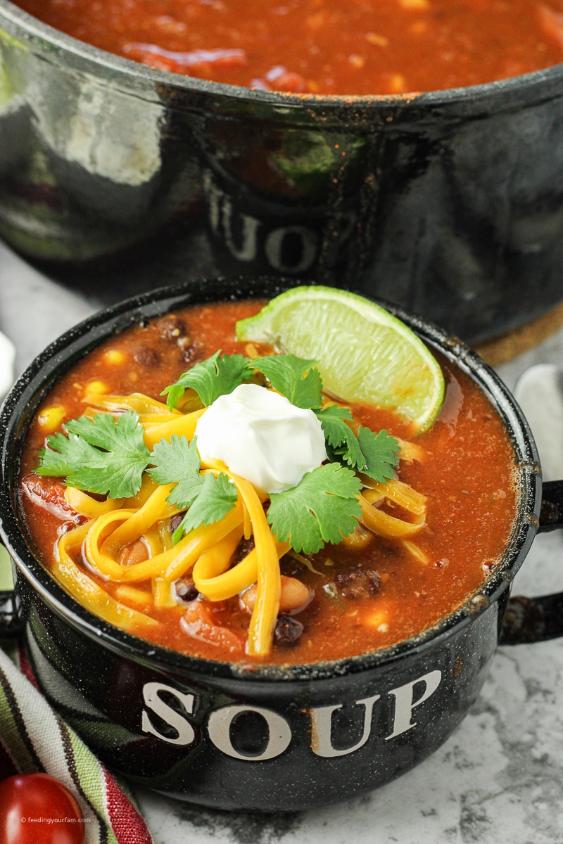 taco soup topped with sour cream, cheese and cilantro