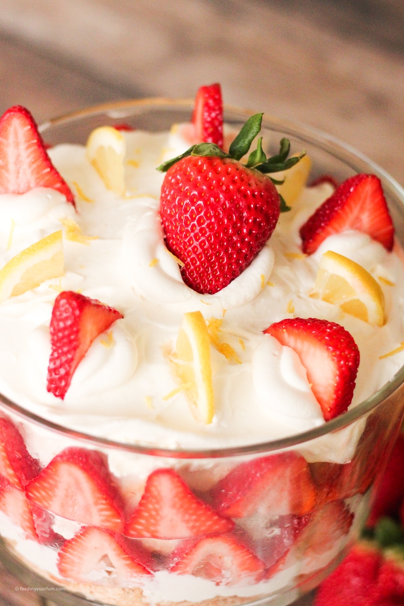 layered strawberry dessert topped with sliced strawberries and lemons