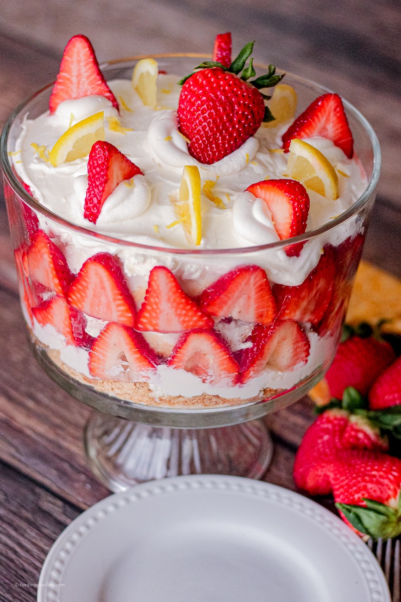 strawberry trifle topped with sliced strawberries and lemons 