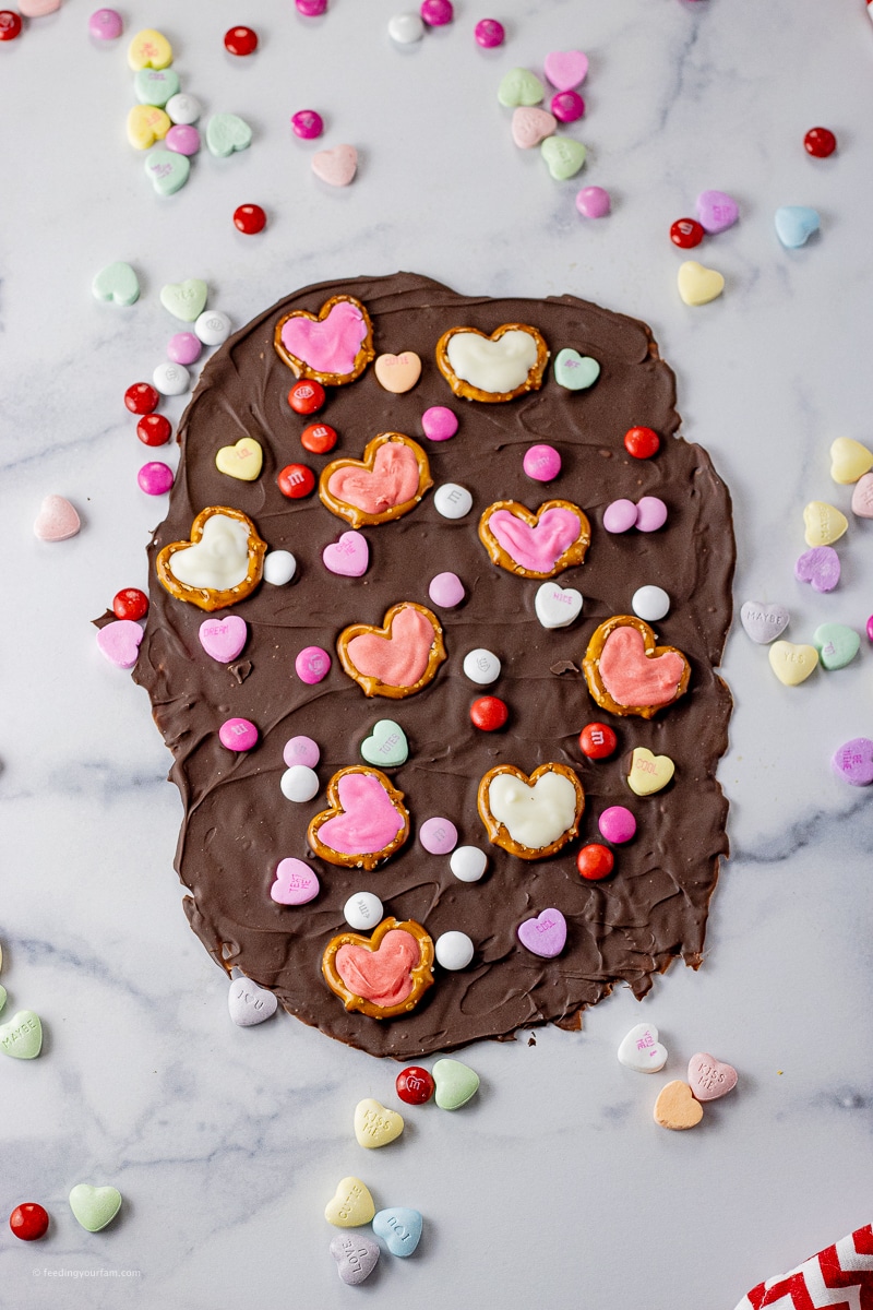 spread out chocolate topped with Valentine's candies and pretzels