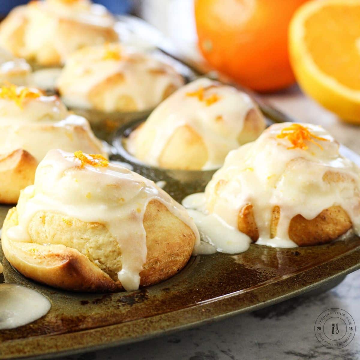 orange rolls in a muffin tin pan