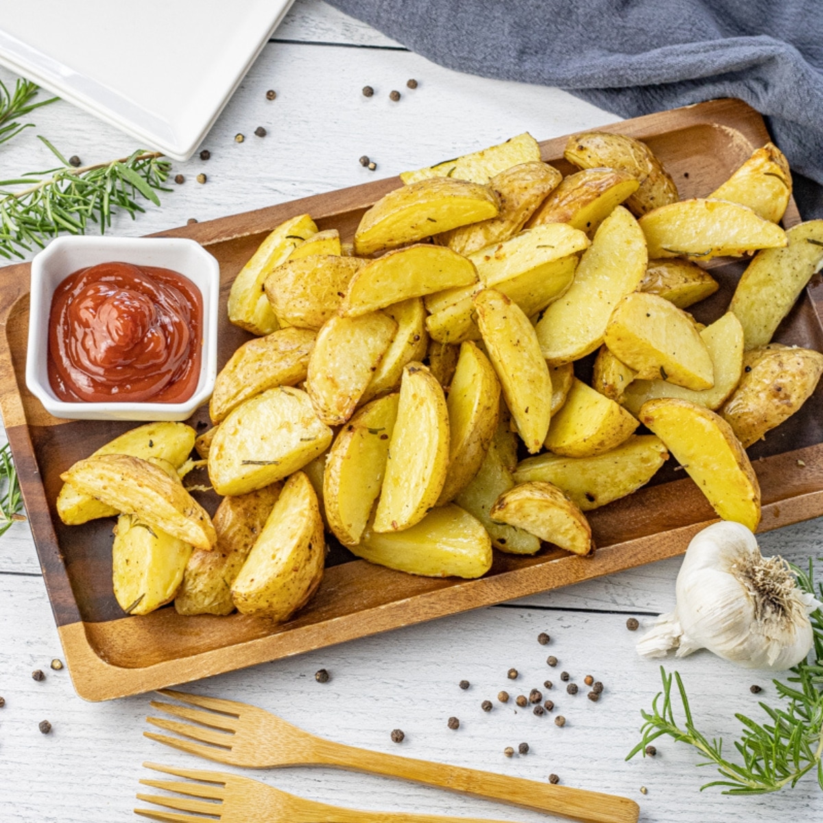 potato wedges on a wooden platter with a bowl of ketchup
