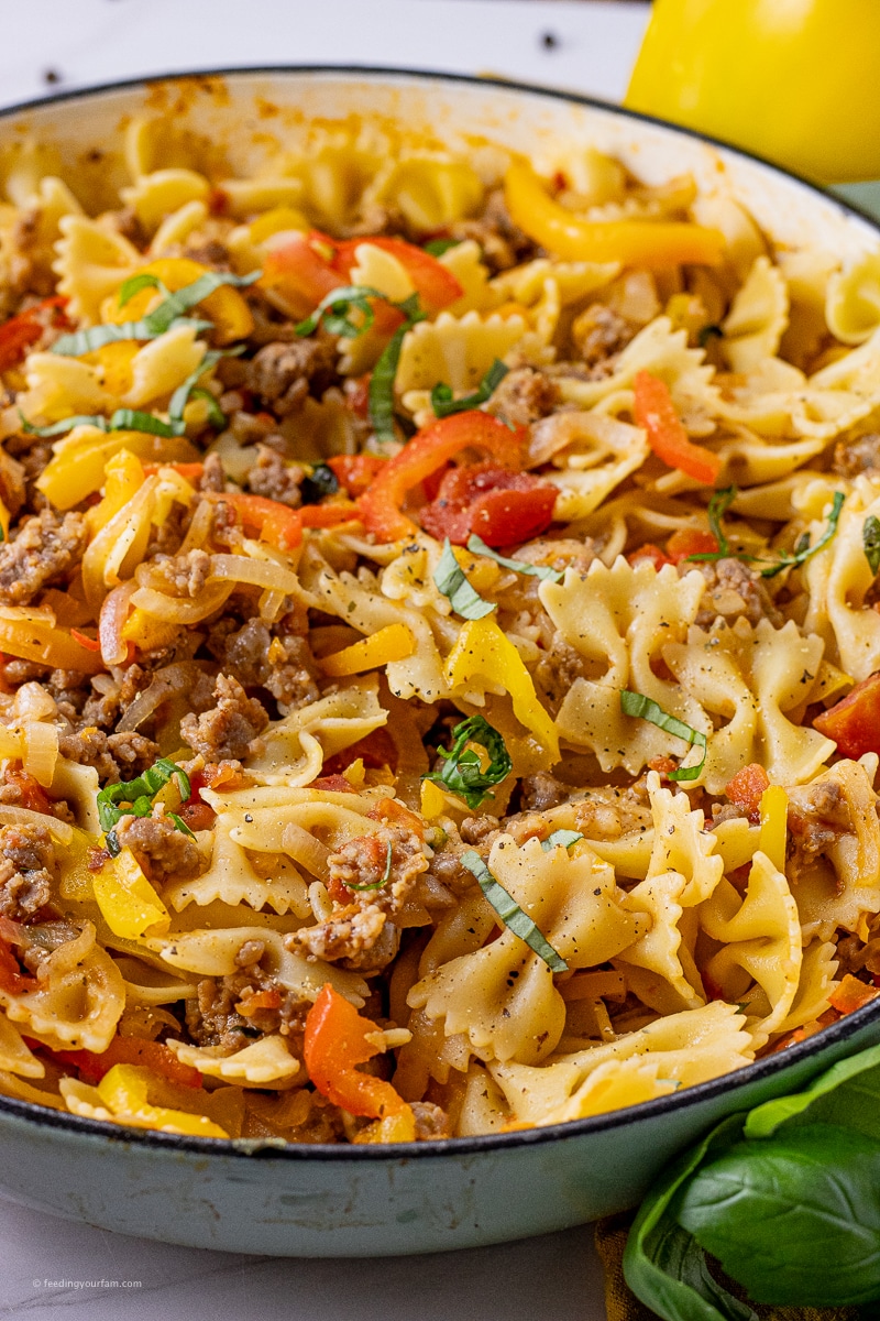 bowtie pasta with peppers, onions and sausage in a large skillet
