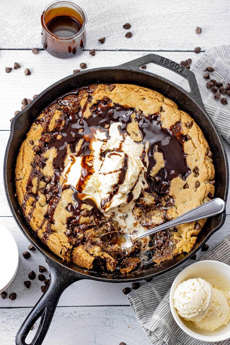 chocolate chip cookie baked in a cast iron skillet topped with hot fudge and ice cream
