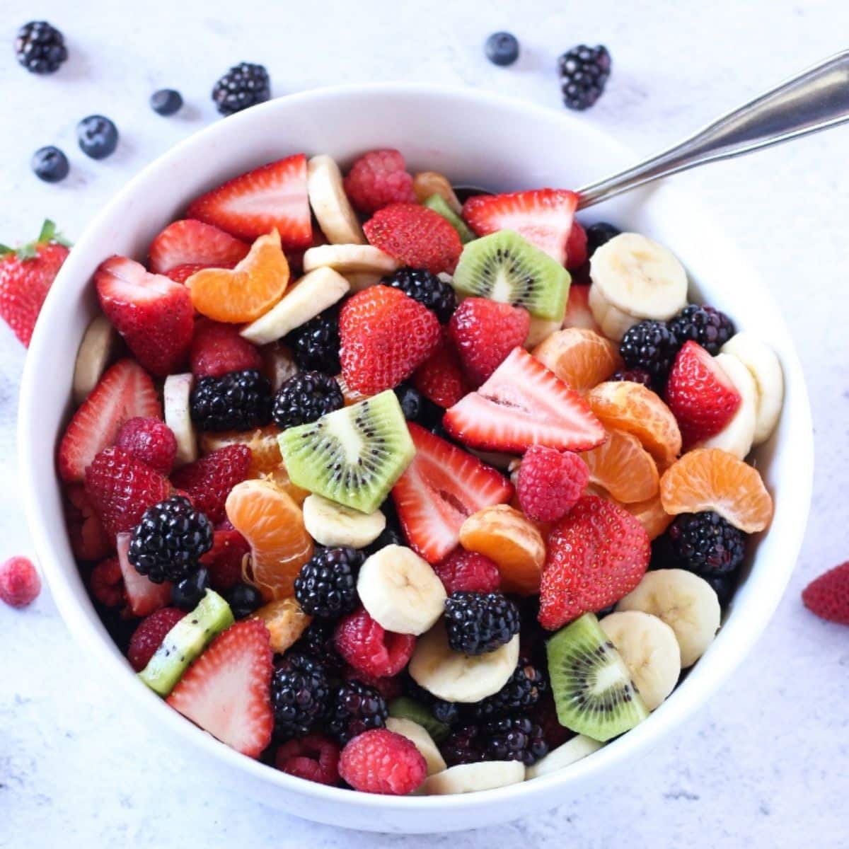 fruit salad made with strawberries, raspberries, kiwi, bananas and blackberries