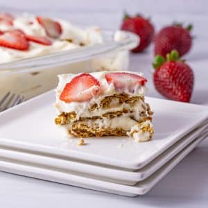 cake slice made with layers of graham crackers, pudding and strawberries