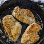 3 chicken breasts that have been cooked in a black cast iron skillet