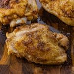 cooked chicken thigh on a wooden cutting board