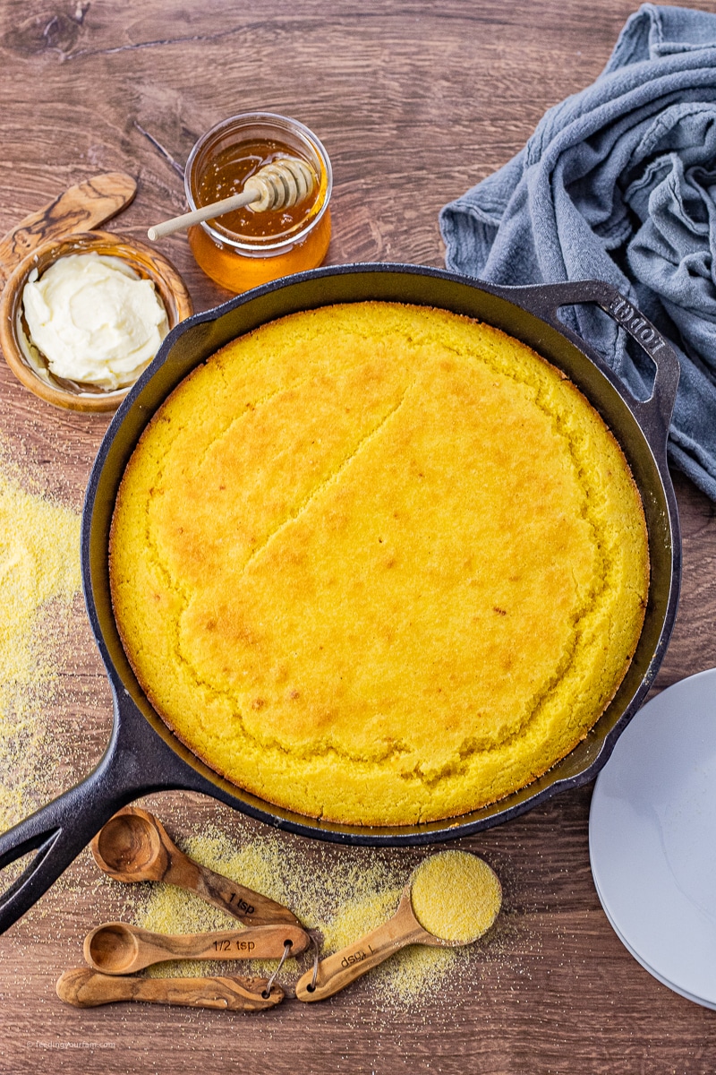 large cast iron skillet cornbread on a wooden background 