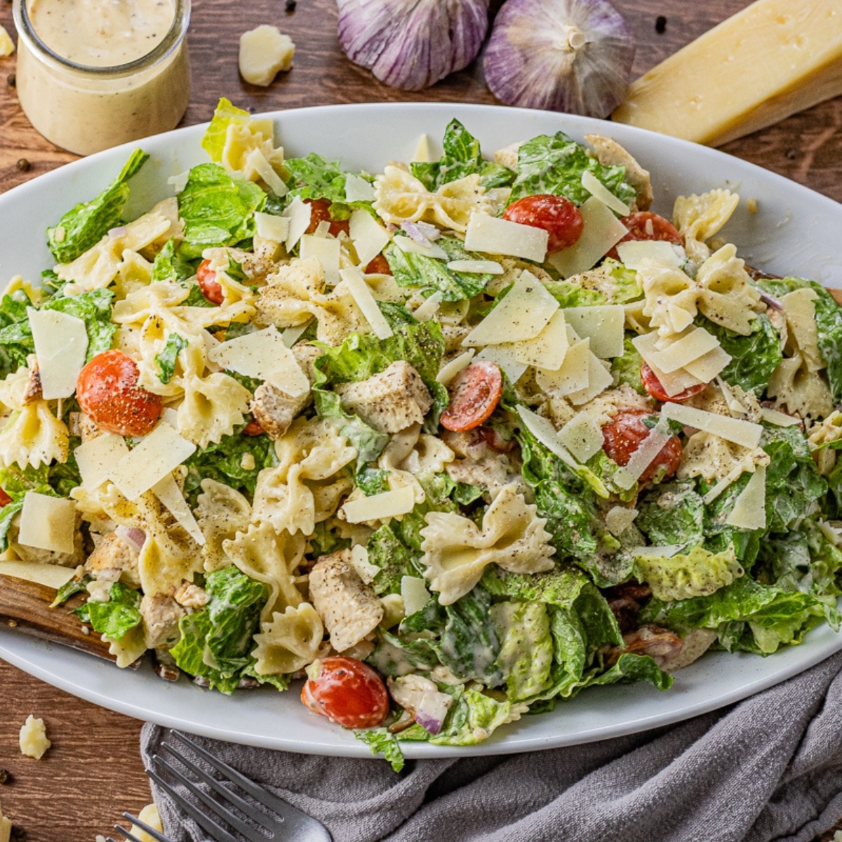 salad made with chicken, romaine lettuce, parmesan, tomatoes and bowtie pasta