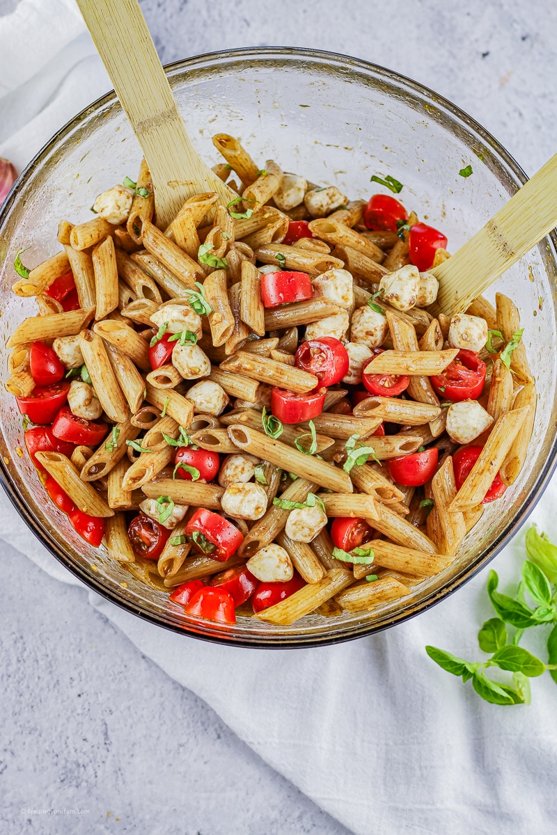 pasta salad made with penne pasta, sliced tomatoes, mozzarella and fresh basil