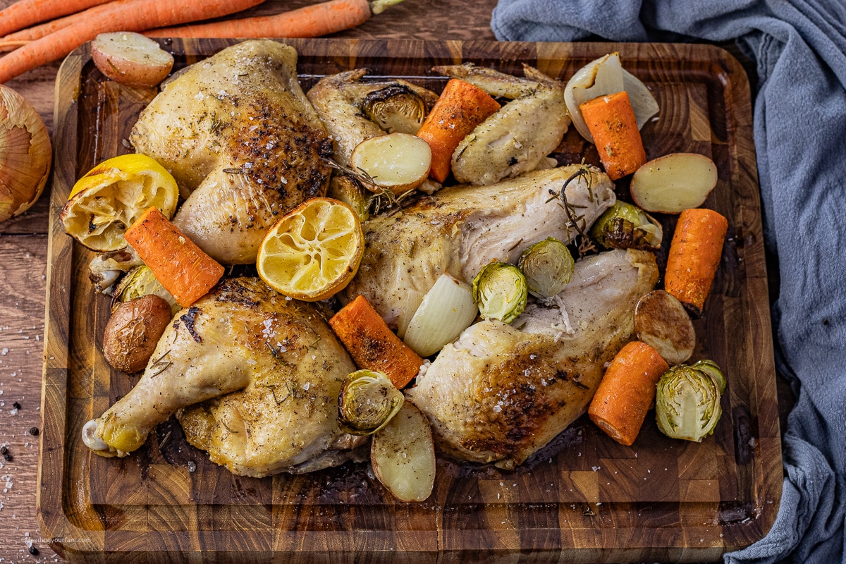 roasted chicken sliced into pieces on a wooden cutting board