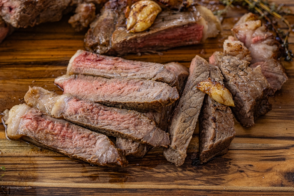 sliced new york steak on a cutting board