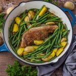 pork tenderloin cooked in the oven in a cast iron skillet with potatoes and green beans