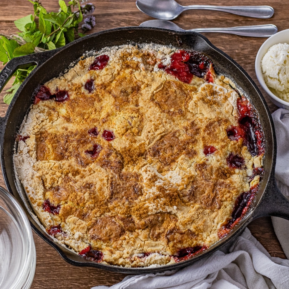 cake baked in a cast iron pan made with cherry pie filling and crushed pineapples