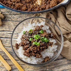 glass bowl with ground beef in a soy sauce sauce over rice