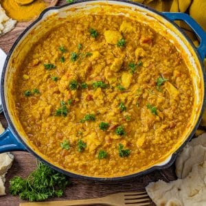 red lentils and chicken in a coconut curry cooked in an enameled cast iron pan