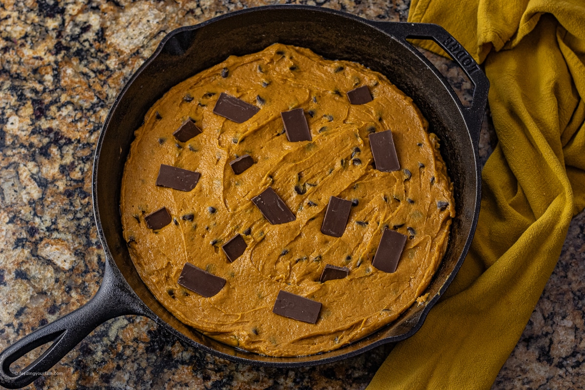 uncooked pumpkin chocolate cookie in a cast iron skillet