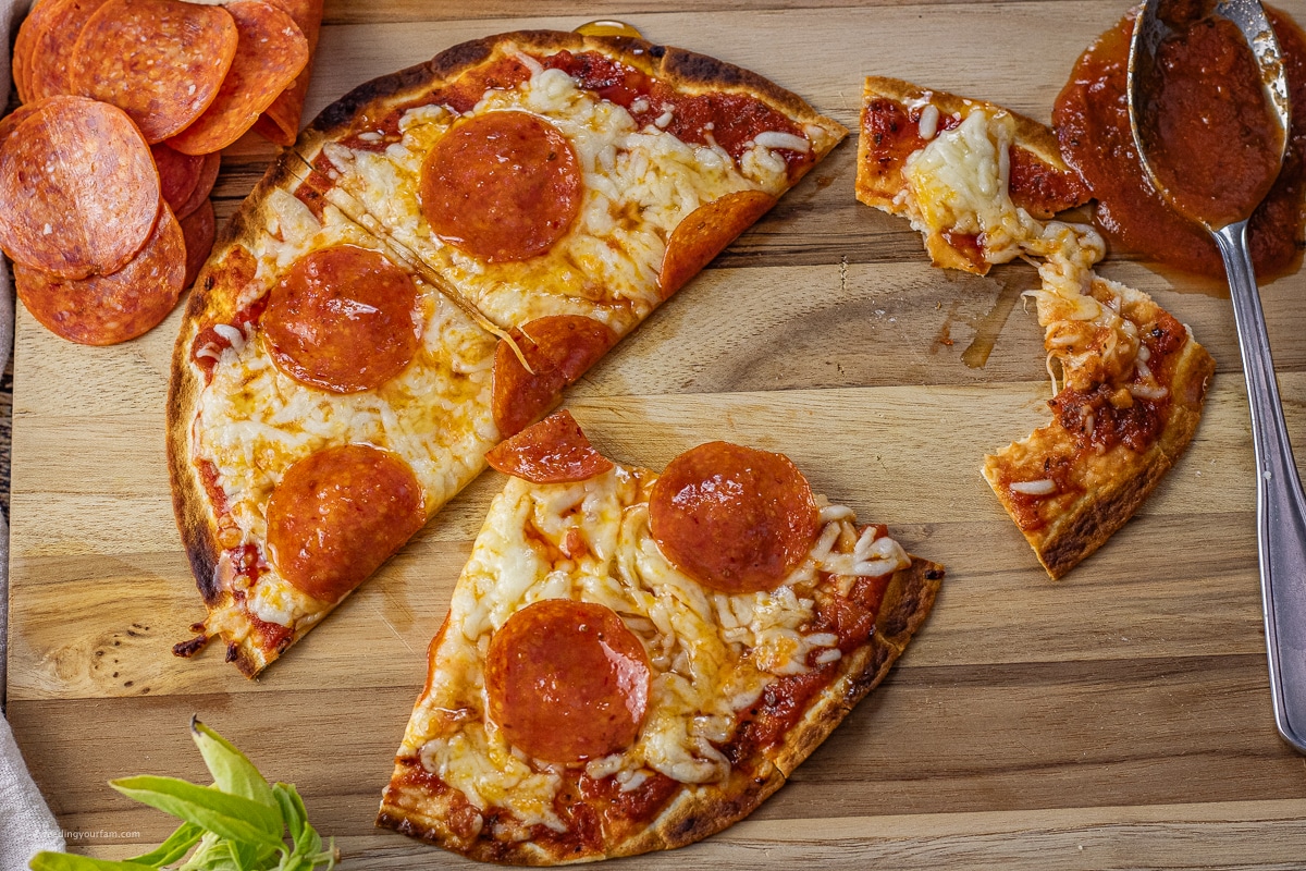 pepperoni pizza on a tortilla shell cut into fourths 