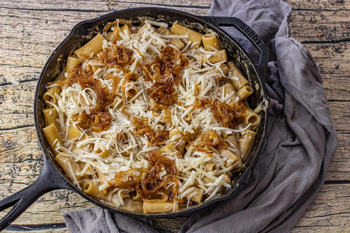 rigatoni pasta in a french onion sauce in a cast iron skillet