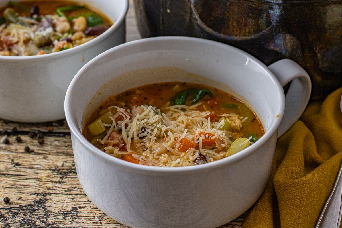 white soup bowl filled with minestrone soup with beans and vegetables