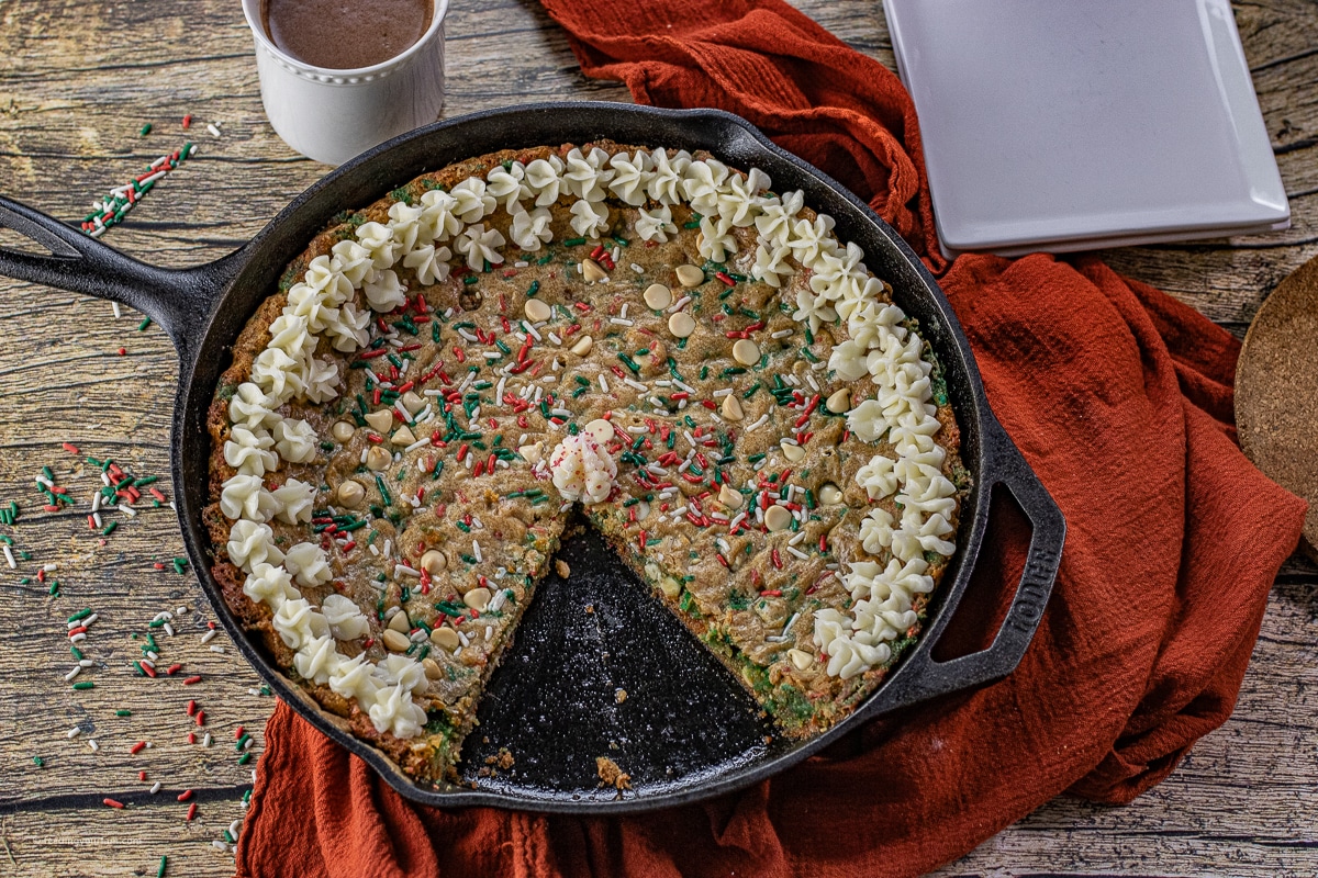 cast iron skillet cookie with red and green christmas sprinkles topped with star frosting