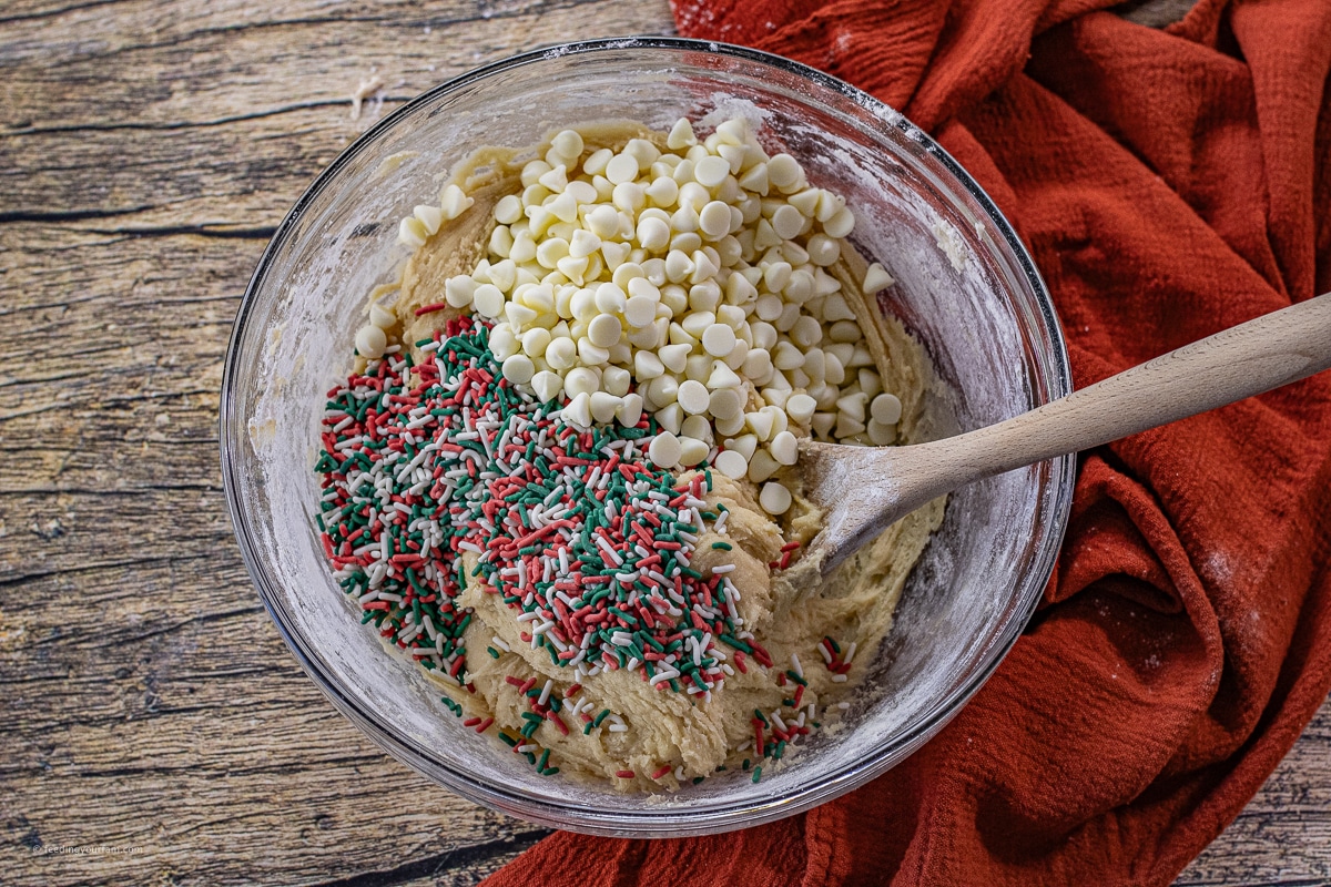 bowl of cookie dough with red and green sprinkles and white chocolate chips