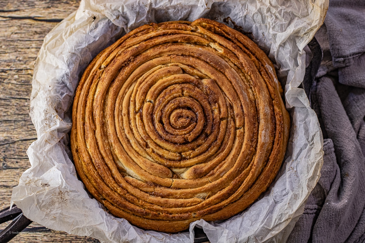 baked giant cinnamon roll cake in a cast iron skillet