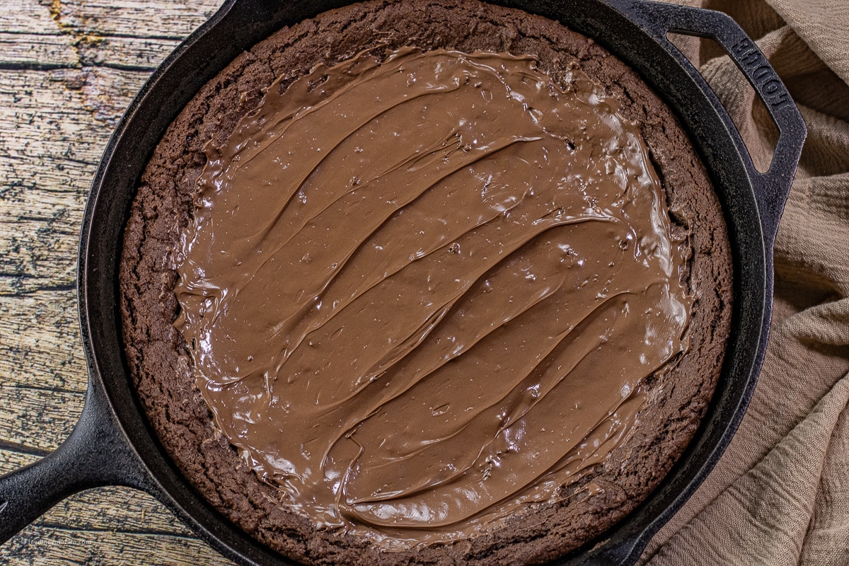 chocolate cookie baked in a cast iron skillet, topped with melted milk chocolate