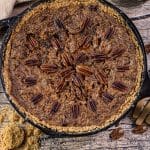 pecan pie baked in a cast iron skillet with pecans on top