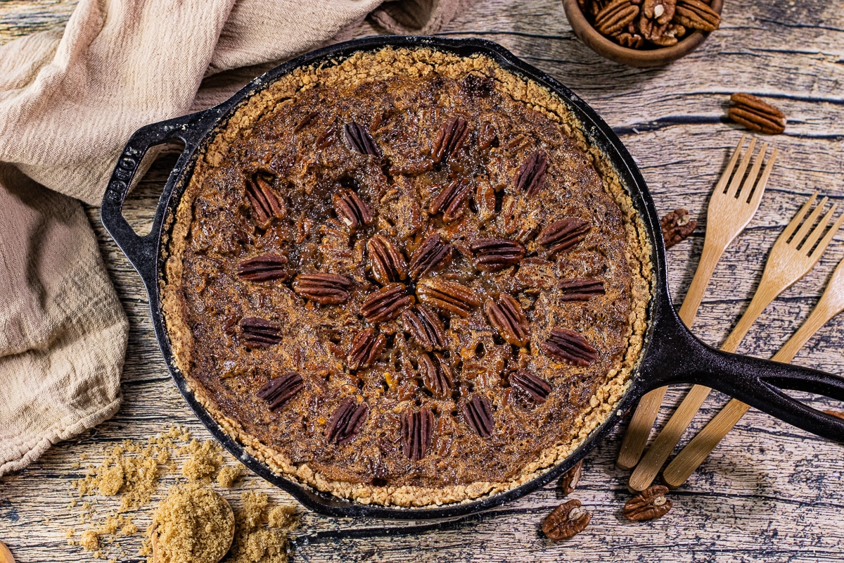 cast iron skillet with a pecan pie baked in it