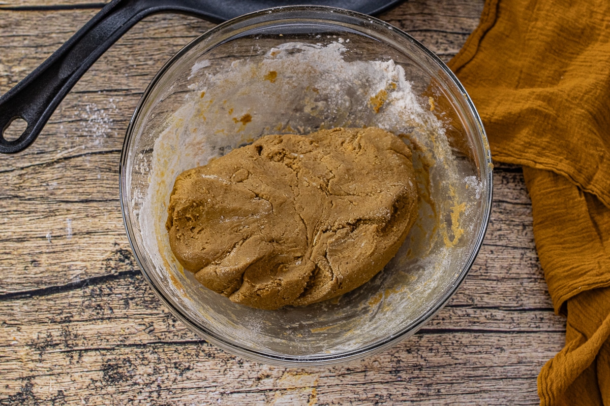 ball of gingerbread dough in a glass mixing bowl