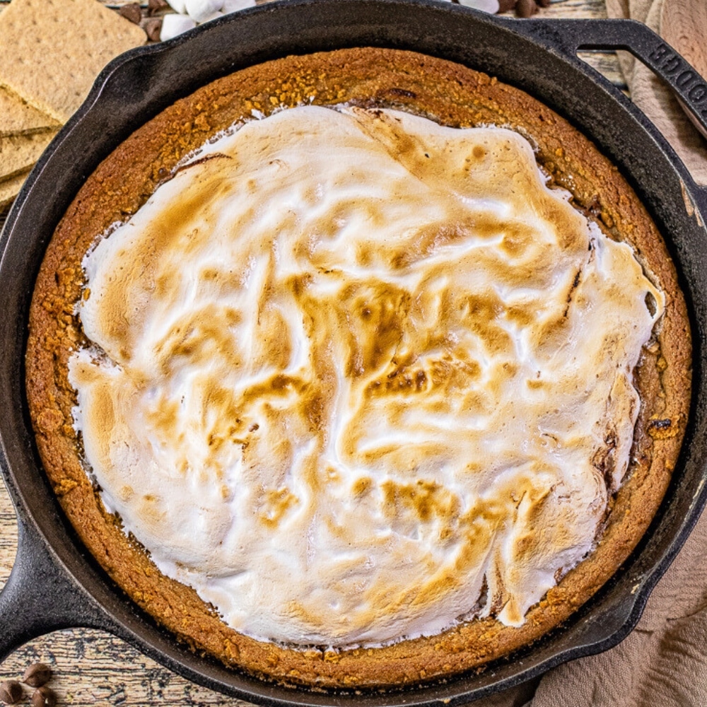 skillet cookie with a graham cracker cookie crust topped with melted chocolate and toasted marshmallow