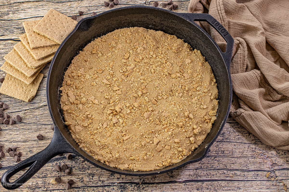 uncooked graham cracker cookie crust in a cast iron skillet 