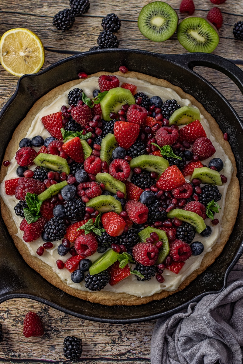 Crisp lemon sugar cookie topped with a soft cream cheese frosting and fresh fruit make this fruit pizza a show stopping dessert.