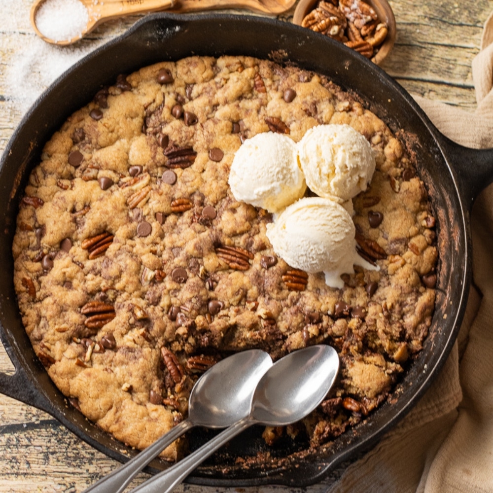 brown butter chocolate chip pecan skillet cookie with ice cream in a cast iron skillet