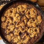 skillet cookie with brownie on the bottom and pieces of browned cookie on top. Brookie Cookie in a skillet.
