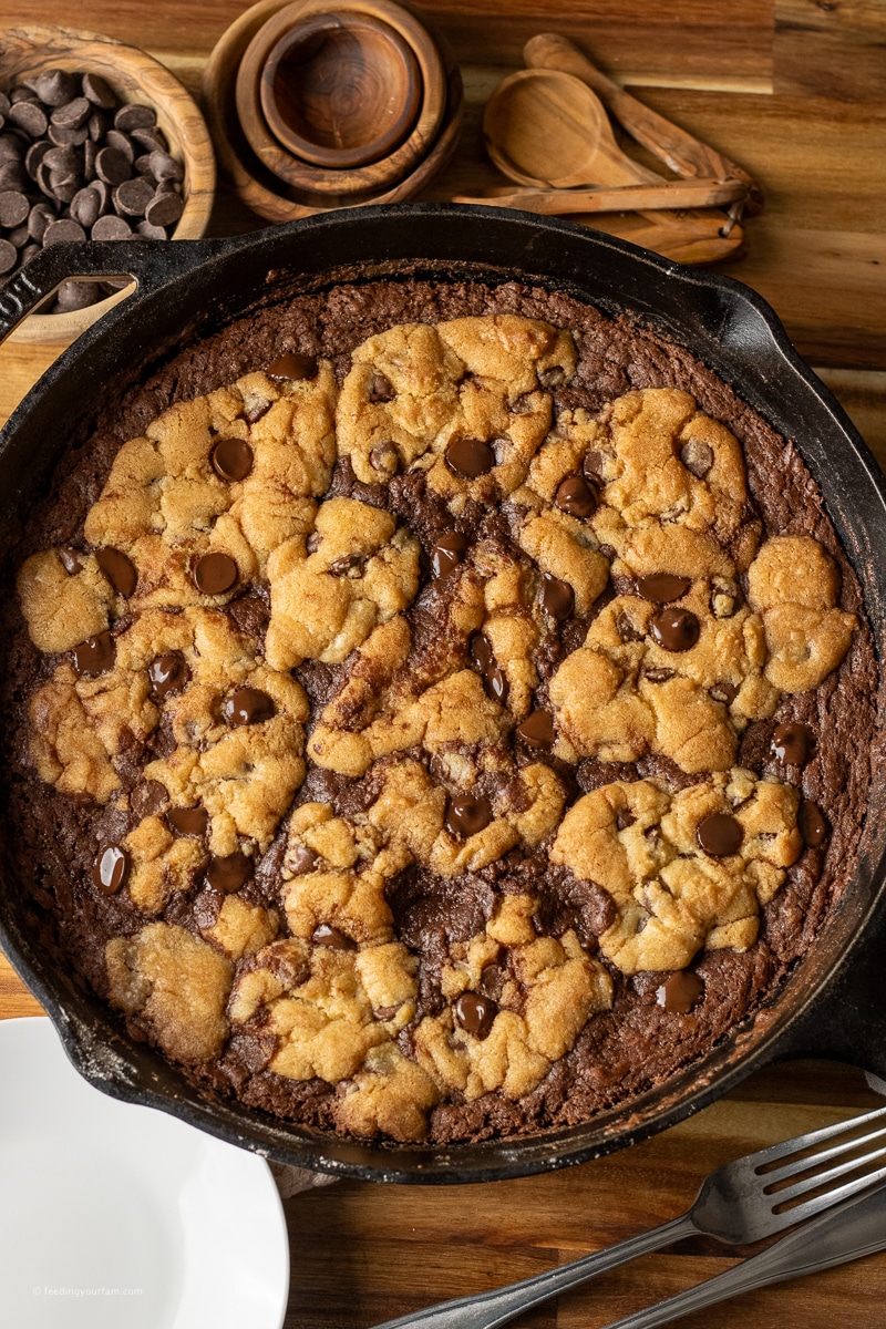 skillet cookie with brownie on the bottom and pieces of browned cookie on top. Brookie Cookie in a skillet. 