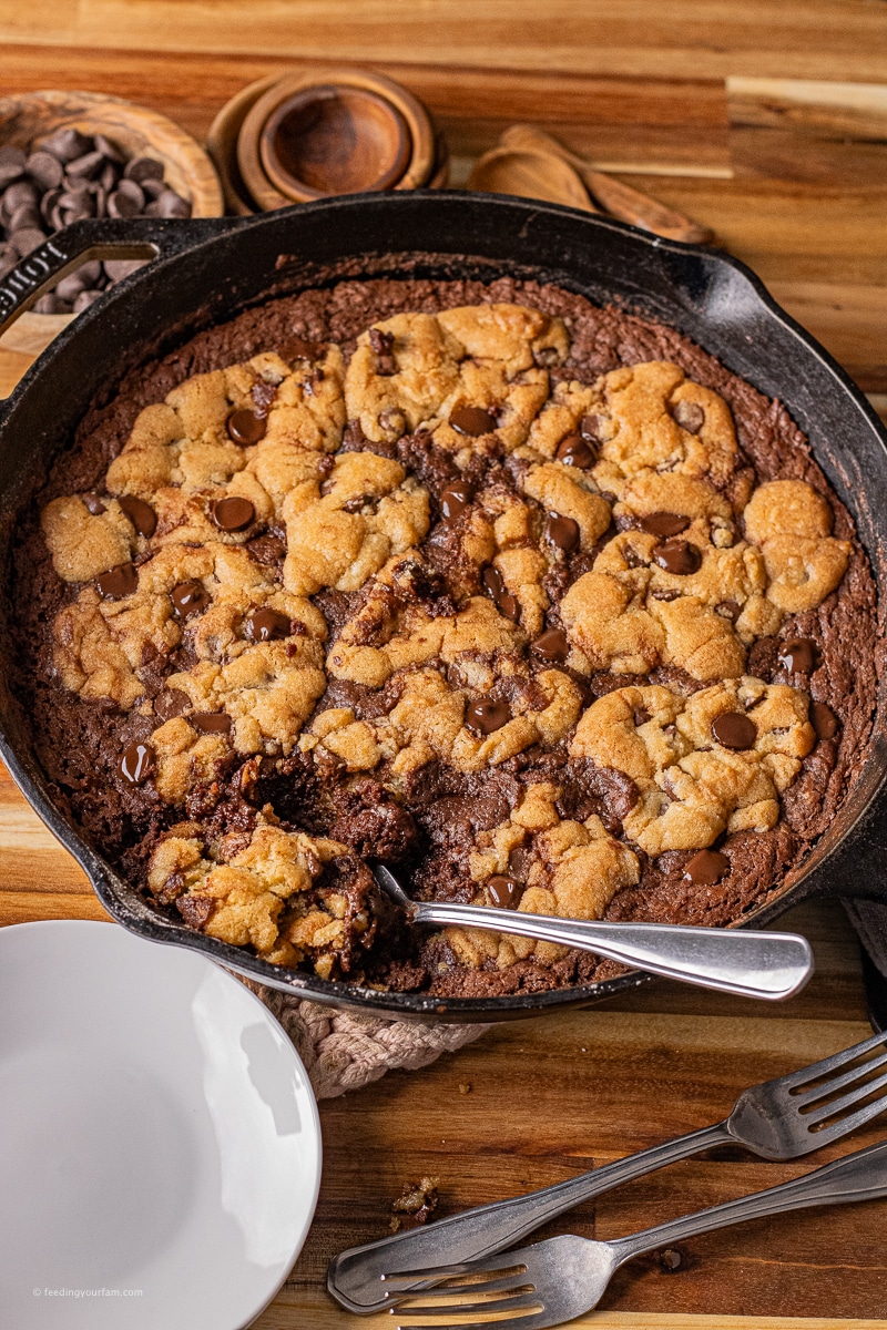 brookie bars baked in a cast iron skillet with brownie on bottom and chocolate chip cookie on top