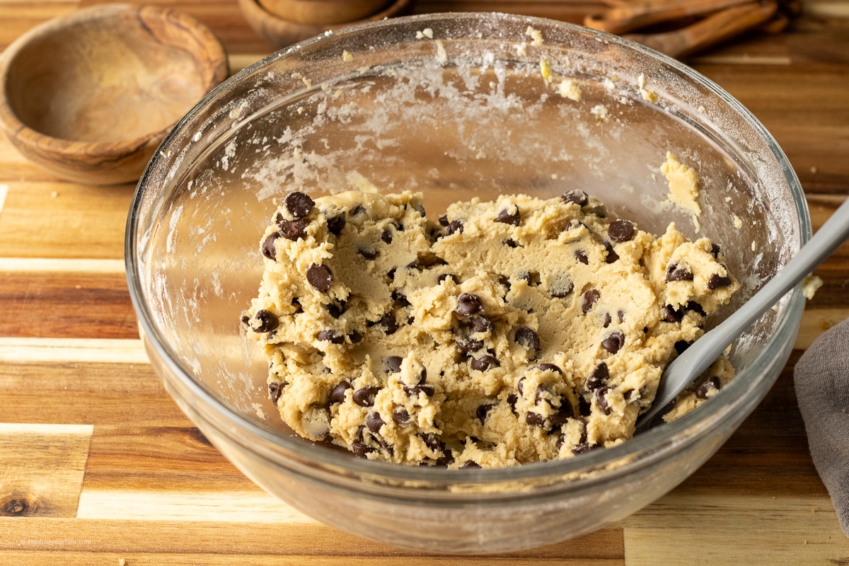 chocolate chip cookie batter in a glass mixing bowl
