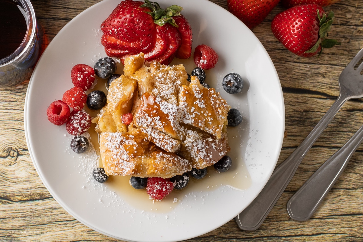 baked french toast casserole on a plate with berries