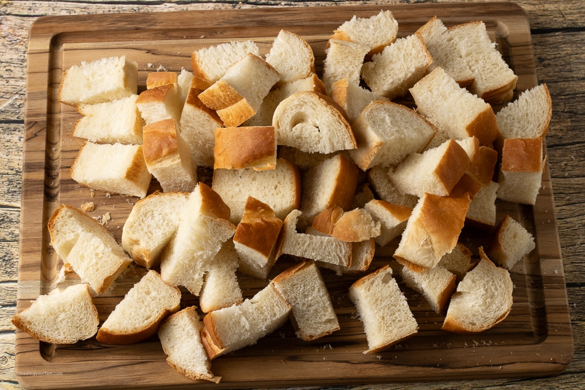 French bread sliced into chunks on a wooden cutting board