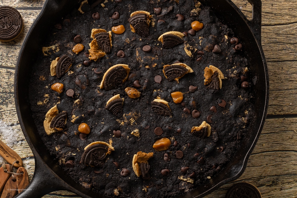 black cookie dough topped with crushed Oreos, caramel pieces and chocolate chips